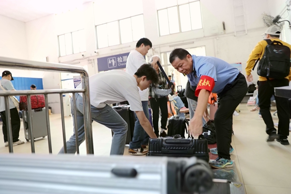 融水站党员突击队帮助旅客搬运大件行李。覃晓平摄
