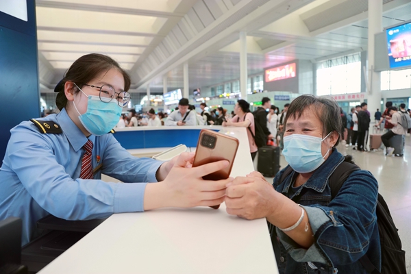 秦蓉蓉帮助老年旅客查询车次信息。于莉摄