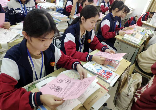 学生们在认真阅读《致家长的一封信》。苏利宣摄