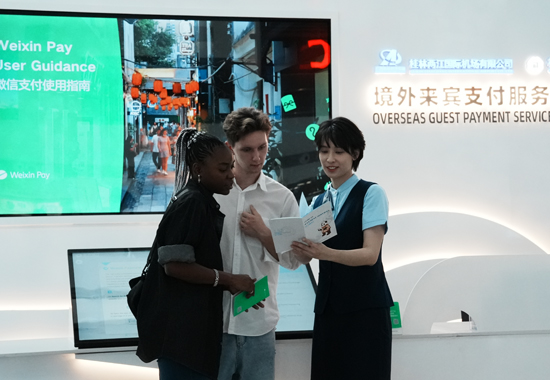 桂林银行工作人员向境外来宾介绍支付服务的获取方式和使用流程。桂林银行供图