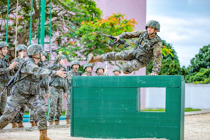 武警官兵在进行四百米障碍训练。