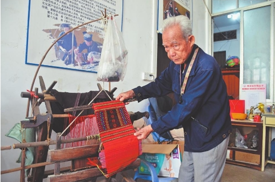 农廷兴展示织布机上的头帕