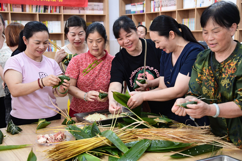 志愿者和居民们在包粽子。