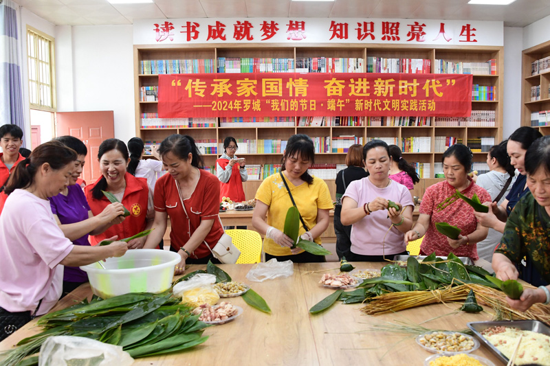 志愿者和居民们在包粽子。
