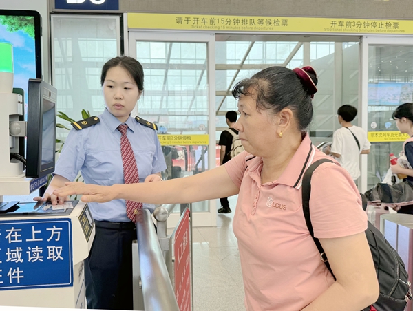 南宁东站工作人员帮助旅客核验车票信息。于莉摄
