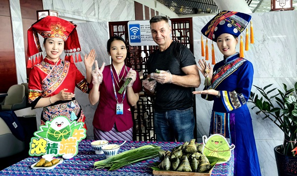南航工作人员邀请旅客包粽子并合影留念。黄丽摄