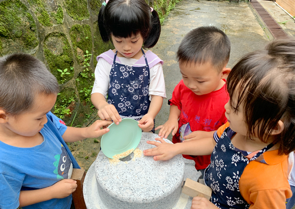 孩子们轮流学磨粉。甘玲玲摄