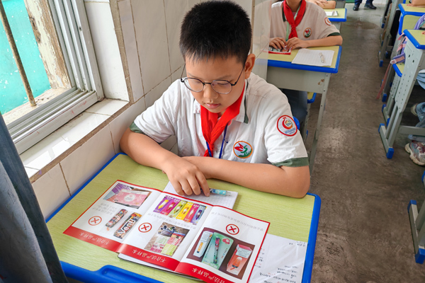 小学生正在学习《无烟校园》宣传册内容。姚晓摄