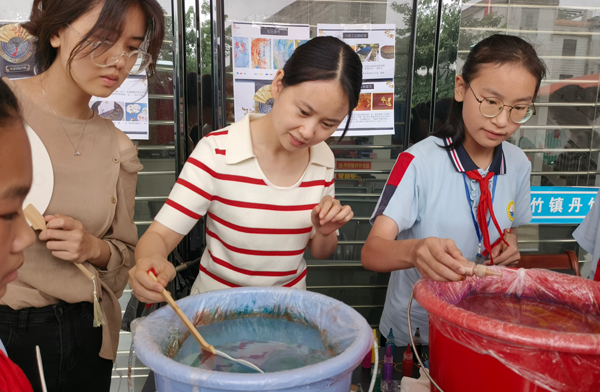 志愿者指导大家如何制作漂漆扇
