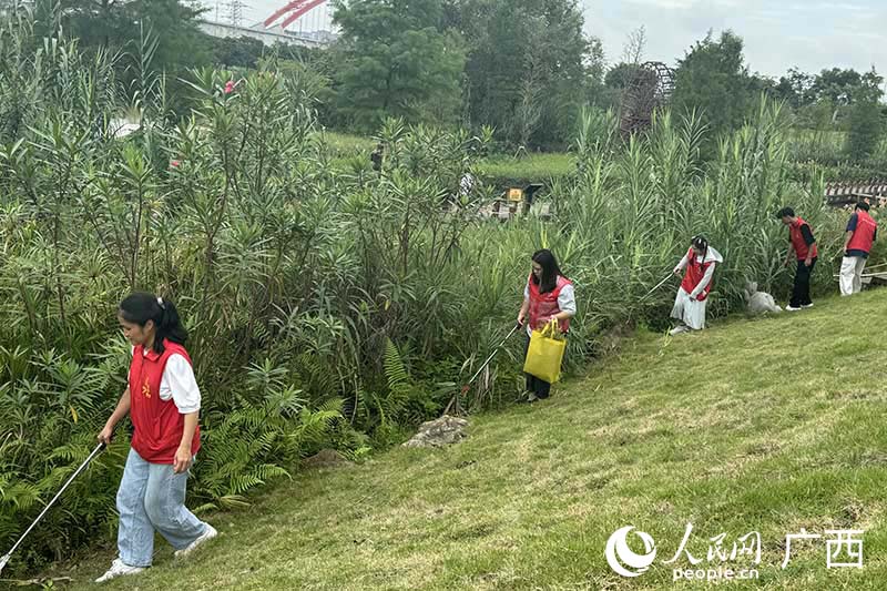 志愿者在那考河河畔清理垃圾。人民网 班小晴摄