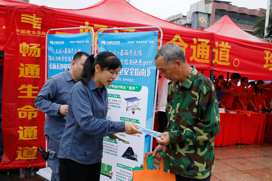 青年志愿者通过向过往市民发放电动车充电桩安全知识等资料，广泛宣传汛期安全用电知识。谢忠敏摄