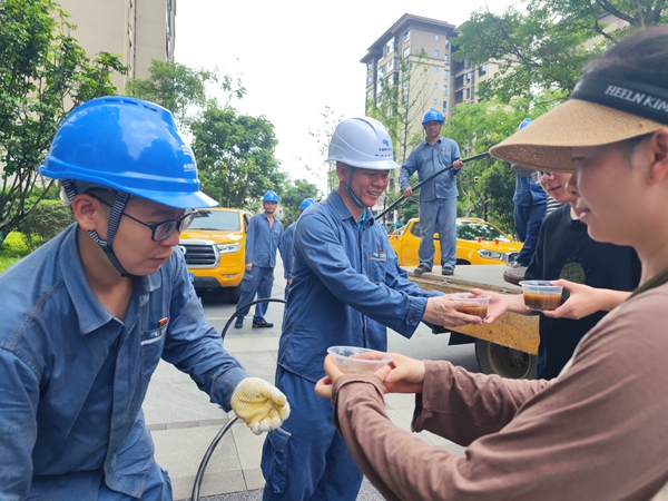 6月22日，桂林市万达翰林府小区群众为正在开展抢修复电的南方电网广西钦州灵山供电局党员突击队员们送上绿豆汤。陈心诚摄
