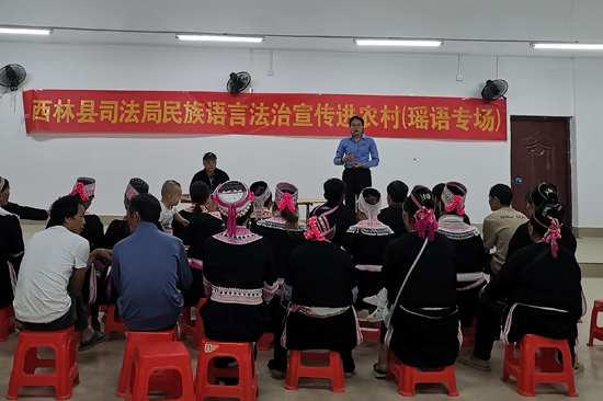 图为法律顾问用少数民族语言开展法律宣传。西林县司法局供图