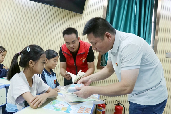 荔浦分公司党员在给小学生赠送文具。