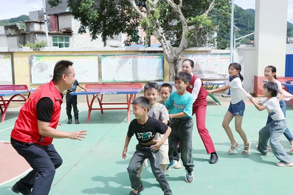 荔浦分公司党员在和小学生游戏互动。