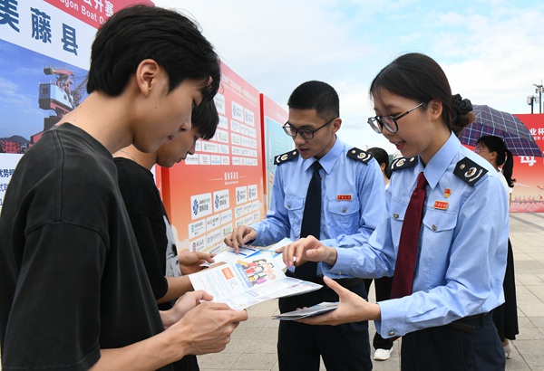 藤县税务局税务干部到龙舟比赛现场宣传税收政策。林秋月摄