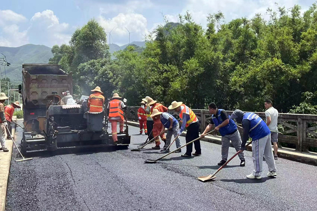 齐心协力铺设桥面道路。