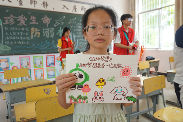 巫头村小学的小学生在展示自己的作品。谭爵玺摄