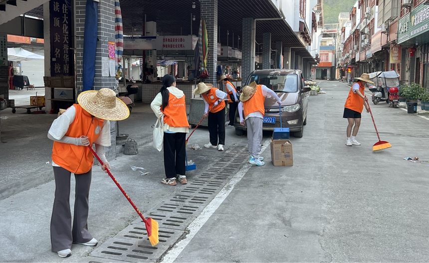 参与街道、市场环境卫生整治。潘宗浪摄