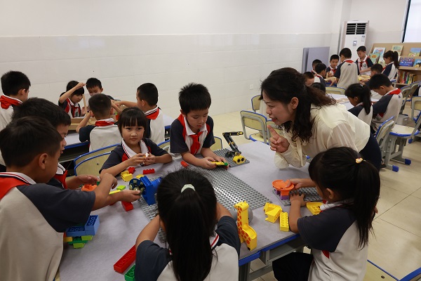周燕在思维拓展活动室里带领孩子们在游戏中学习知识。陈素珍摄