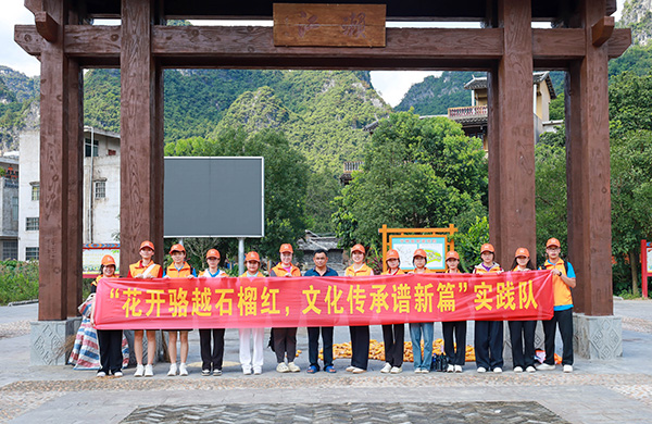 广西职业师范学院团委“花开骆越石榴红 文化传承谱新篇”实践队与耀达村濑江屯糖泡酒制作技艺代表性传承人林宁海合影。黄静霞摄