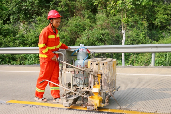 养护人员亮化国道355线路面标线。黄幼玲摄