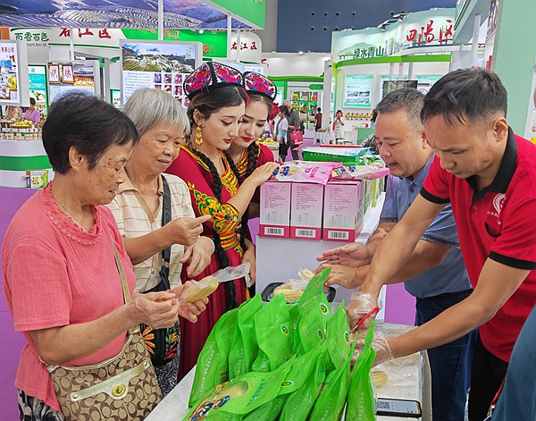 圖為參展企業在縣博會現場推薦忻城的農特產品