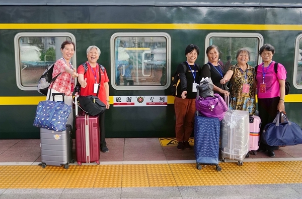 旅客在站台上與旅游專列合影。梁競輝攝