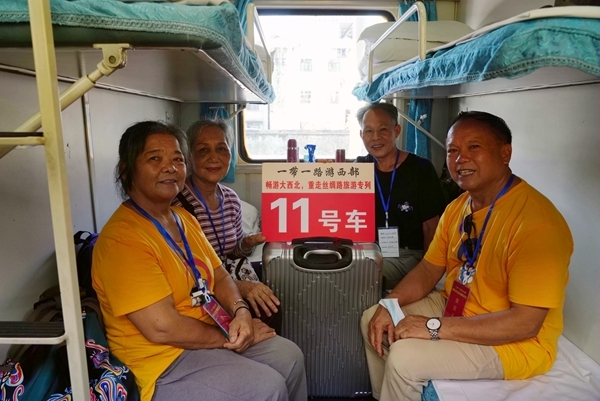 旅客在旅游專列車廂裡合影留念。梁競輝攝
