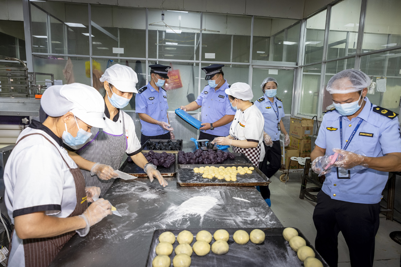 执法人员查看月饼生产原材料是否合格。零达军摄