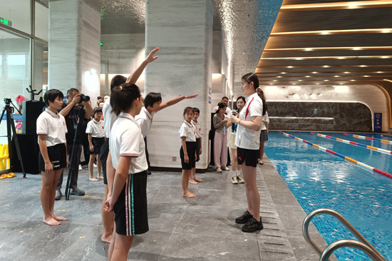 与青少年学生分享蝶泳和自由泳的基础泳姿及动作要领。广旅集团供图