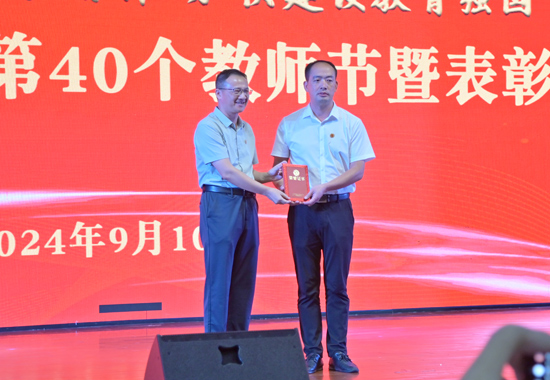 为广西模范教师罗志荣颁发荣誉证书。邓民胜摄