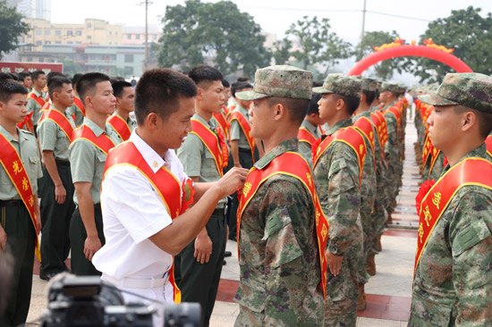 退役老兵为入伍新兵戴上红花。