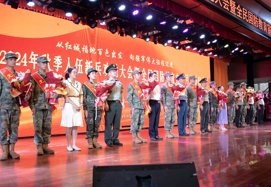为新战士戴绶带、红花，赠送书籍。百色学院融媒体中心供图
