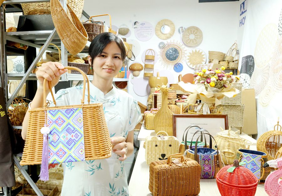 钟思明展示融入民族元素的藤编工艺品。韦颖琛摄