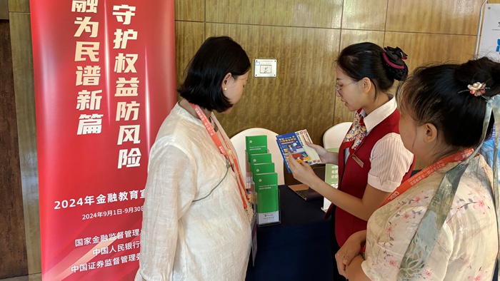 图为华夏银行南宁分行营业部员工向外籍参展商普及金融知识。华夏银行南宁分行供图