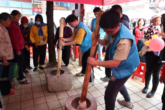 学生与居民一起打糍粑。庞海瑜摄