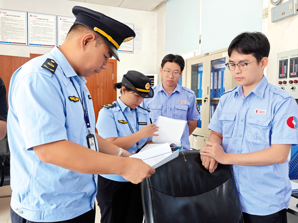 执法人员检查企业资料、台账。记者苏昭宇摄