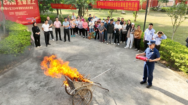 消防宣傳人員講解滅火器的使用方法。