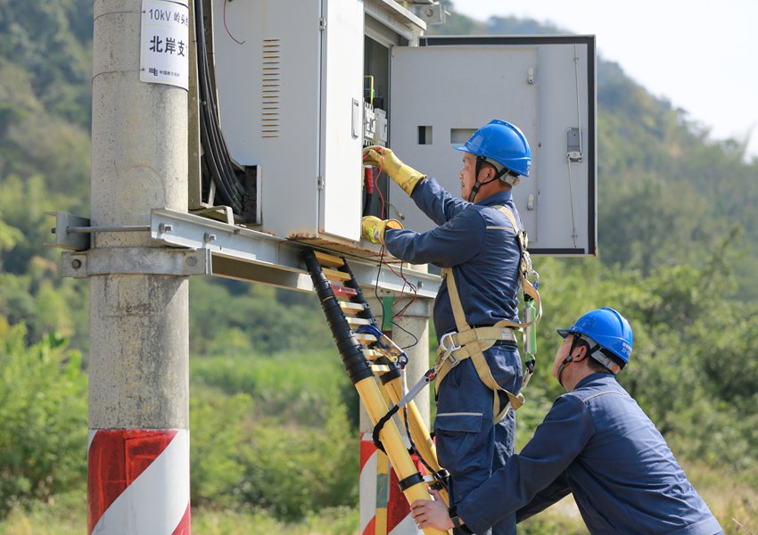 工作人員檢查台區變壓器，保障村民秋收用電無憂。鄧克軼攝