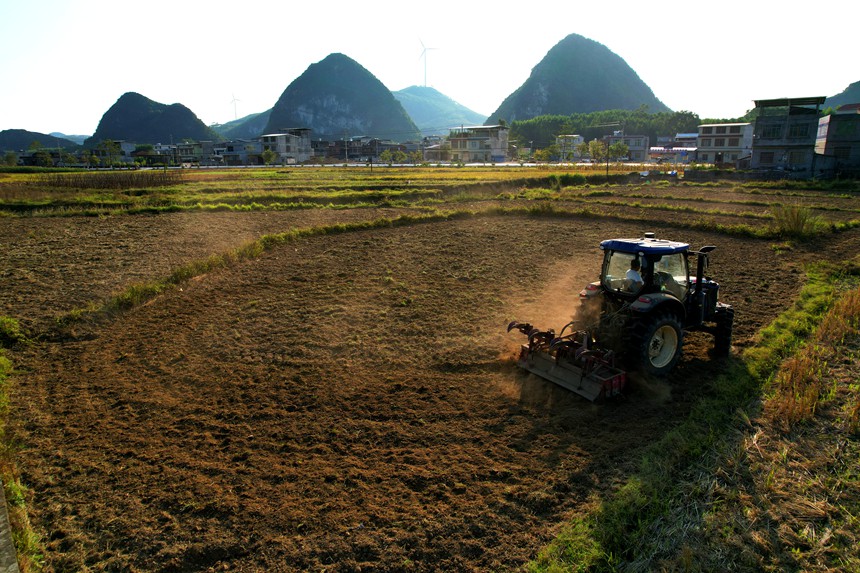 覆土机械紧跟其后，为麦种覆土。忻城县委宣传部供图