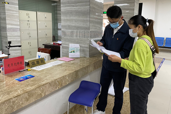烟草工作人员向群众进行宣传。张芳摄