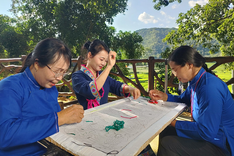 七里刺绣非遗传承人凌漫丽（中）在朔晚村巴查屯大榕树下教授技艺。