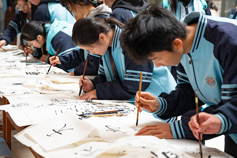 实践团带当地学生体验书法写字。温畹月摄