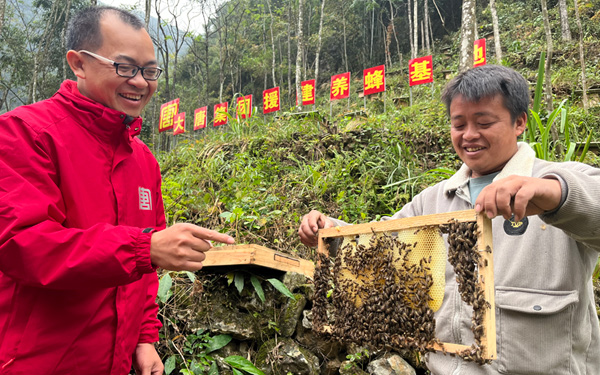 安兰村村民蓝海展示蜂箱蜂蜜。朱新宇摄