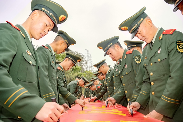 武警官兵在“铭记历史 砥砺前行”的横幅上庄重签名。