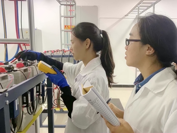 南宁通信段职工正在对机房蓄电池组进行测量记录。秦华林摄