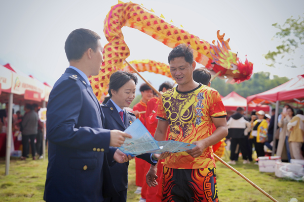 乡庆活动现场，税务干部为群众普及医保知识。胡文豪摄