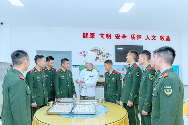 武警官兵学习包饺子技巧。