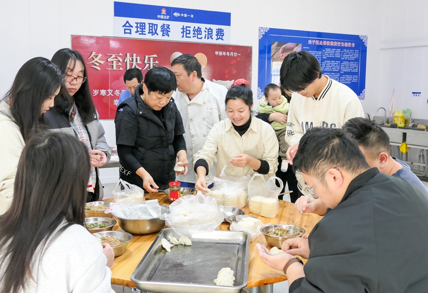 罗鹿高速项目员工围坐在一起包饺子。中国一冶供图